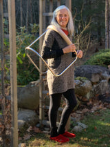 Cilia carrying a birth stool over her shoulder