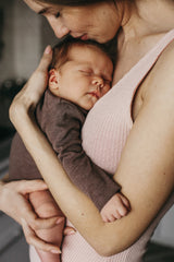 Woman holding a sleeping baby close to her face